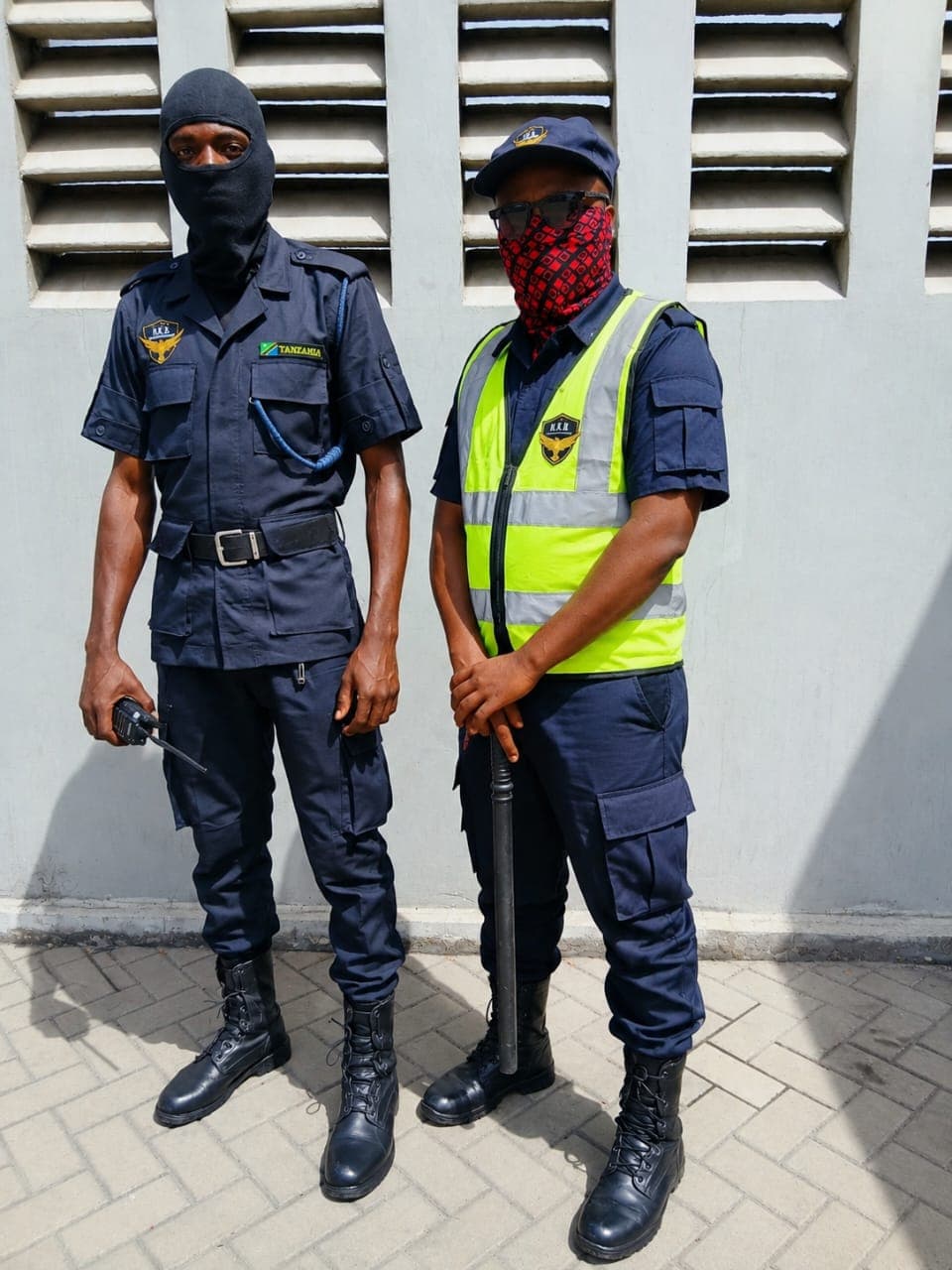Two HKB officers in uniform and hi-vis vest on post